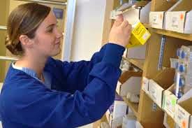 Florence Arizona female pharmacy tech taking item from shelf
